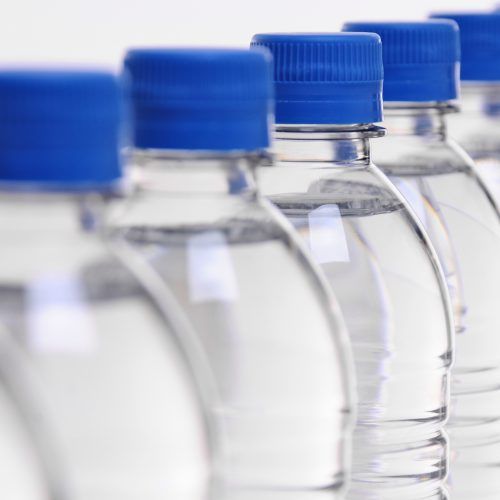 select focus on middle bottle in a row of water bottles