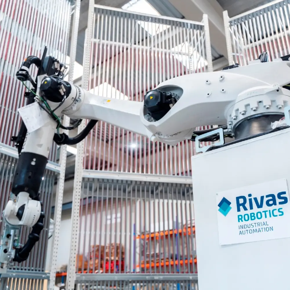 Robot KUKA con garra de horquillas junto al armario de Rivas Robotics
